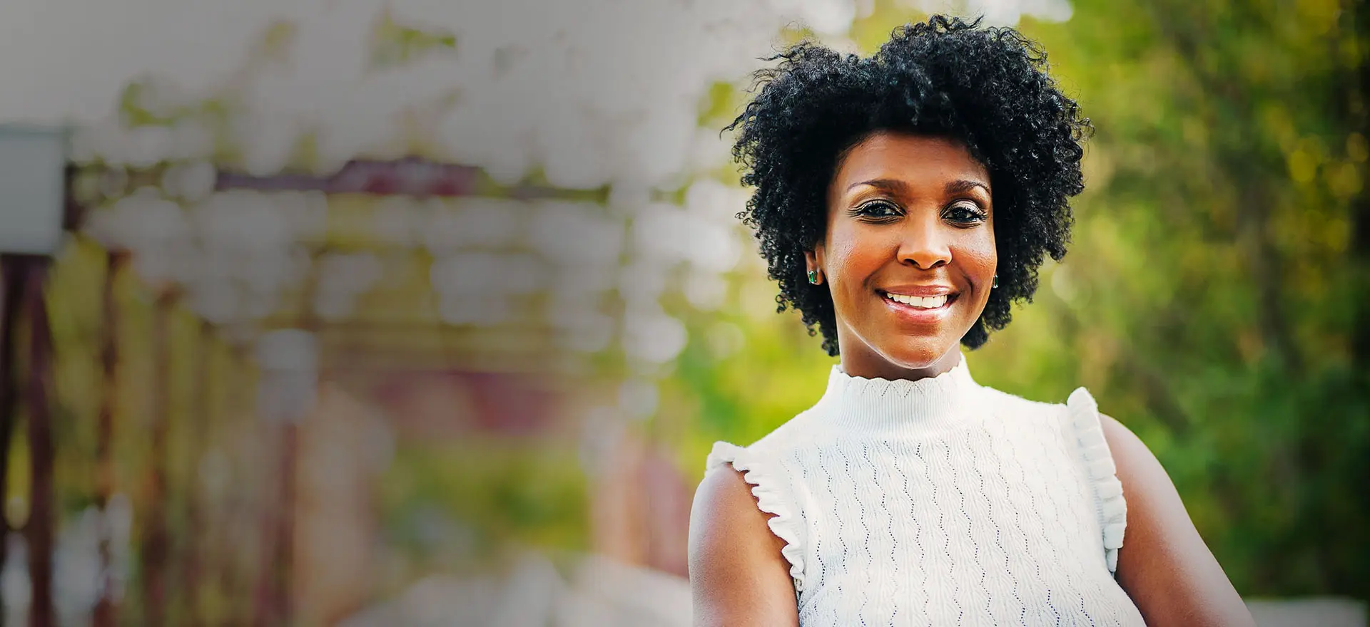 A woman with curly hair smiling for the camera.