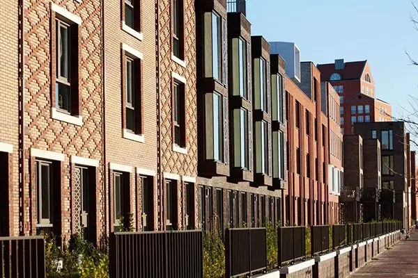 A row of brick buildings with windows and balconies.