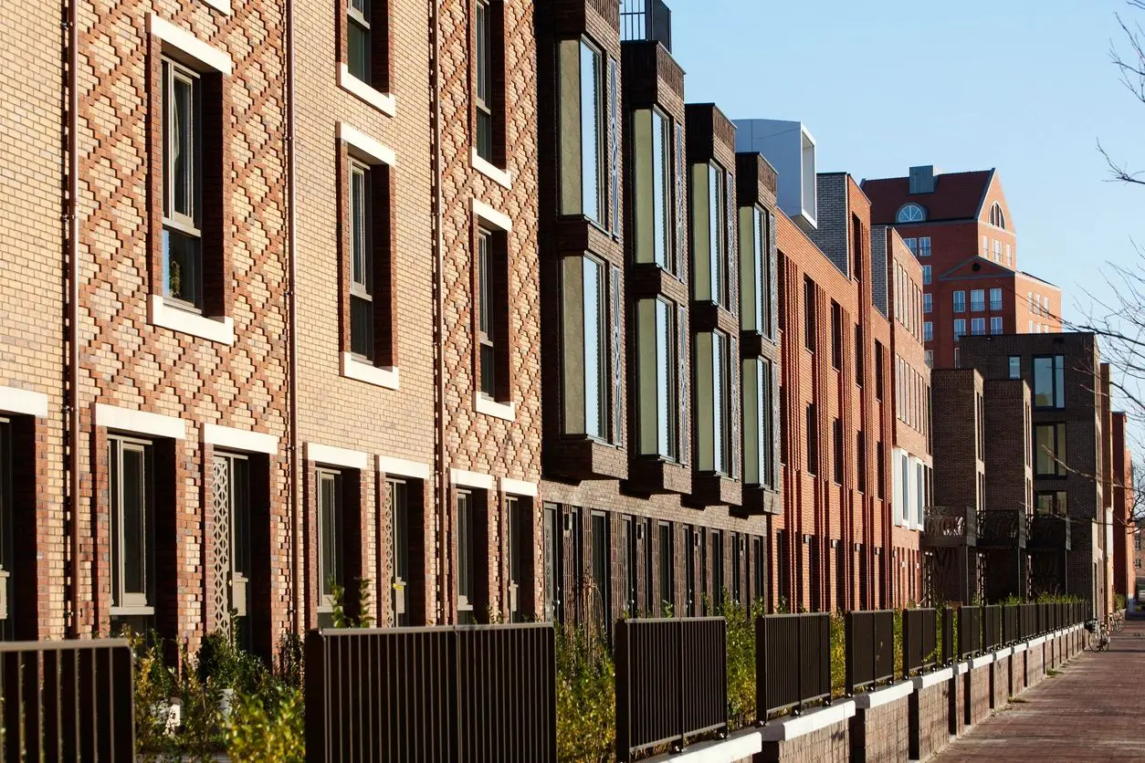 A row of brick buildings with windows and balconies.