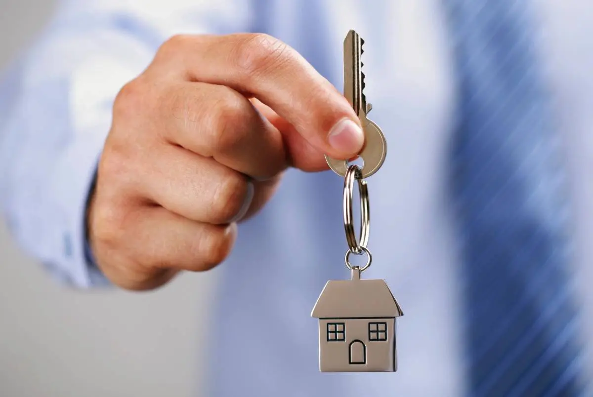 A person holding keys to a house