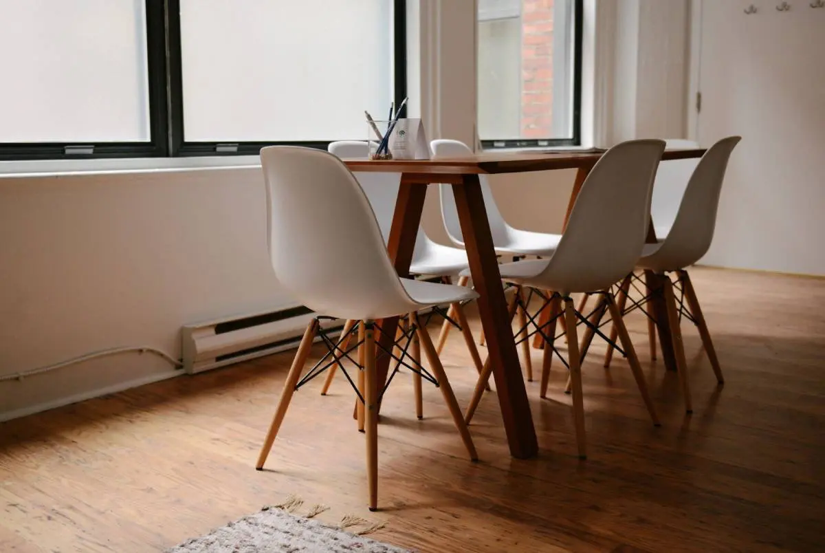 A table and chairs in front of a window.